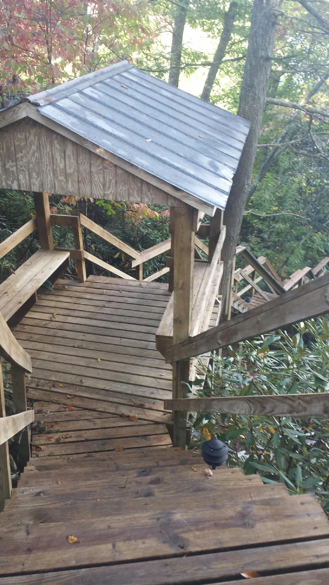 Metal roofed shelter over wooden steps on a wooded walkway — Skylight Repair & Installation work by our crew in Fairlee