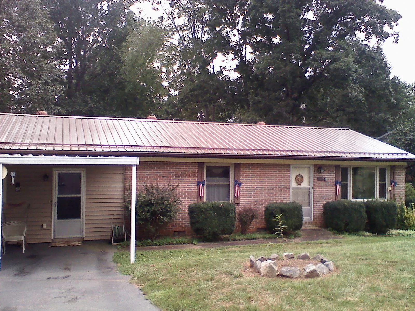 Bronze metal roof and carport on a brick ranch home — Roof Repair work by our crew in Fairlee